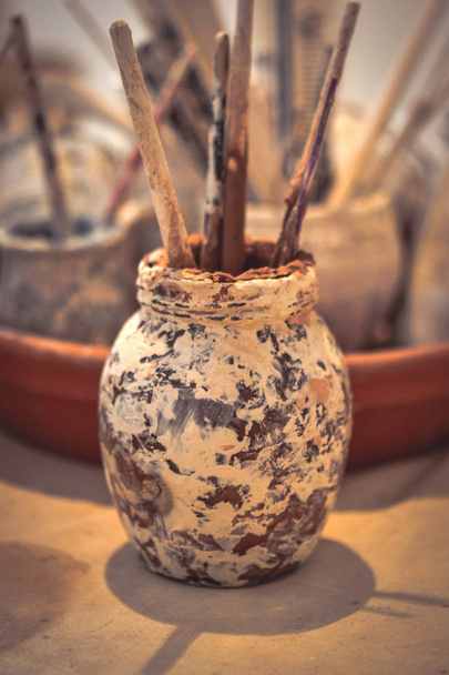 A glass stained with smeared clay with tassels - 写真・画像