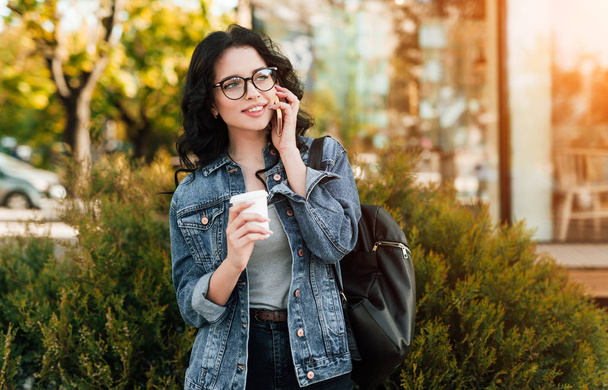 Young woman with hot drink speaking on phone - Photo, image