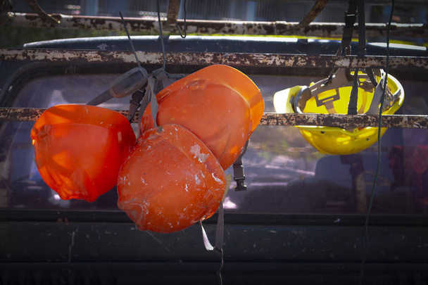 construction helmets hanging on an old pickup truck . - 写真・画像