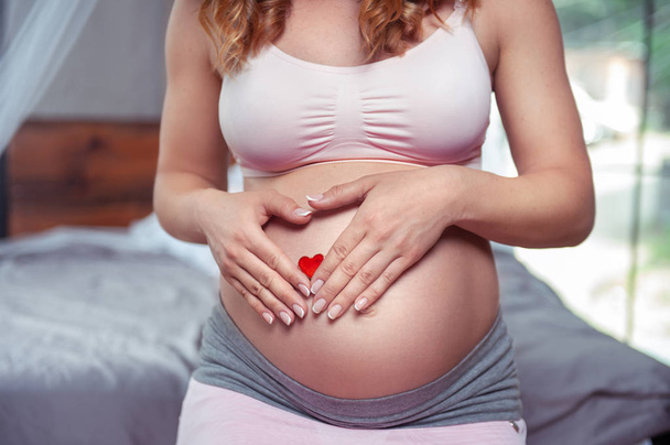 Zwangere vrouw aanraken van de buik close-up - Foto, afbeelding