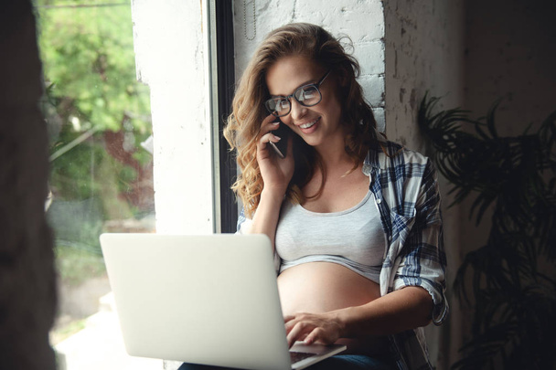 Hamile kadın evde çalışmak için dizüstü bilgisayar kullanımı - Fotoğraf, Görsel
