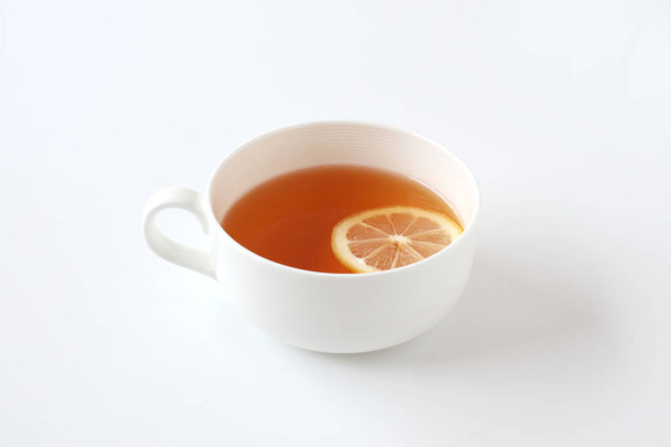 beyaz arka plan üzerinde izole dilimlenmiş limon closeup ile çay fincan - Fotoğraf, Görsel