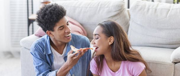 Juguetón negro chica degustación su novios pizza
 - Foto, Imagen