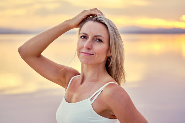 Middle-aged sportive woman posing during sunset on nature - Foto, Imagem