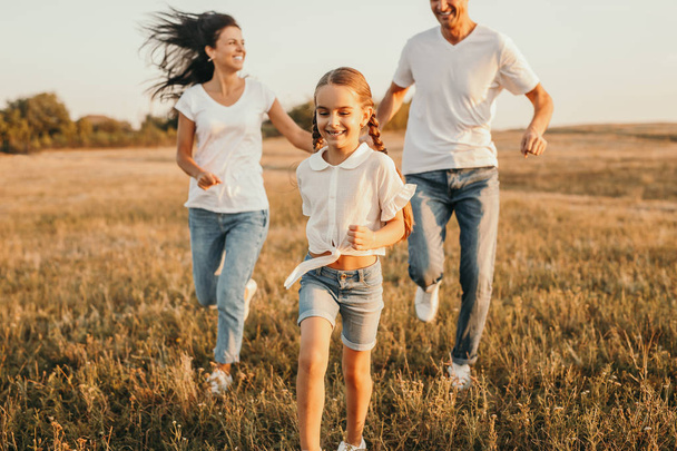 Happy family running in field - Fotó, kép