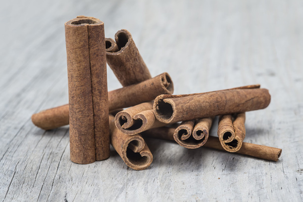 Cinnamon sticks on a wooden background - Photo, image