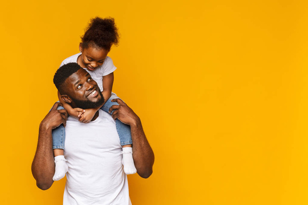 Cute african girl sitting on daddys shoulders - Photo, Image