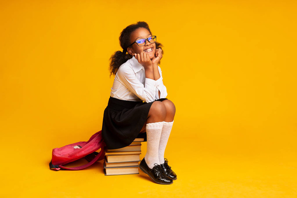 Mosolyogva első Grader Girl ül könyv stack a Studio - Fotó, kép