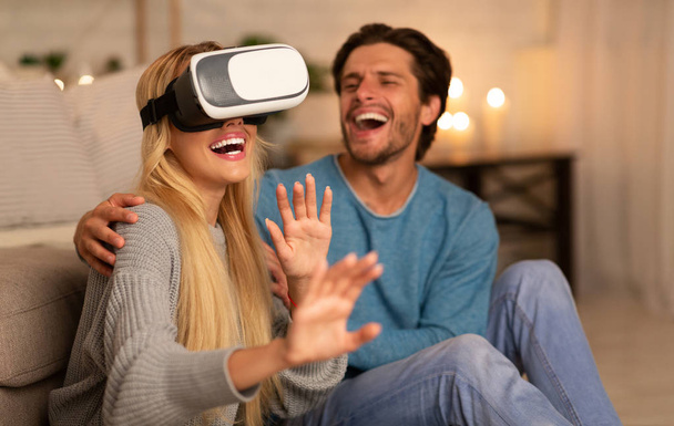 Ευτυχισμένο ζευγάρι χρησιμοποιώντας VR ακουστικά που διασκεδάζουν στο σπίτι - Φωτογραφία, εικόνα