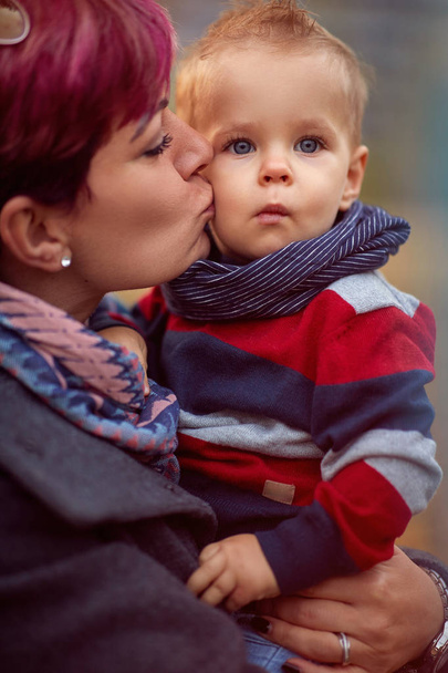 Mother with son at the autumn park enjoying together - Фото, изображение