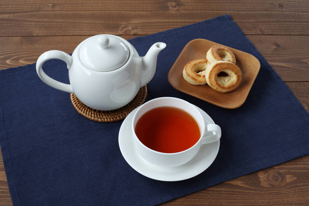 tasse de thé avec anneau scone biscuit sur plaque avec isolé sur la table
 - Photo, image