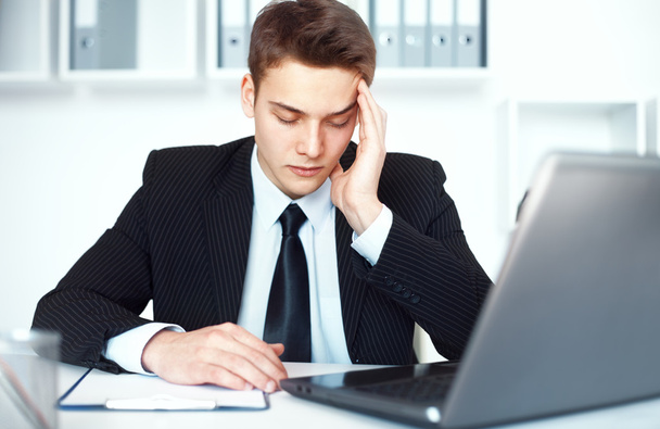 Tired young businessman in office - Photo, image