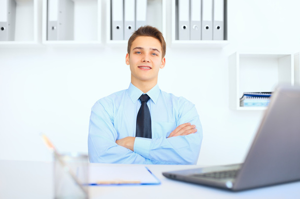Young smiling businessman at his workplace in office - Foto, Imagem