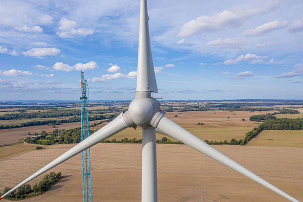 A large wind farm with many wind turbines is built near a small  - Photo, Image