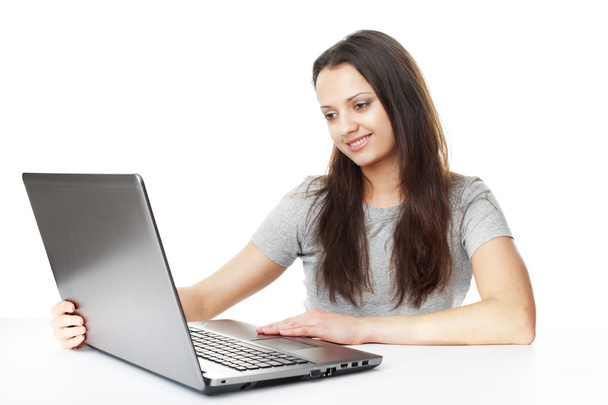 pretty young brunette woman with laptop at table - Foto, afbeelding