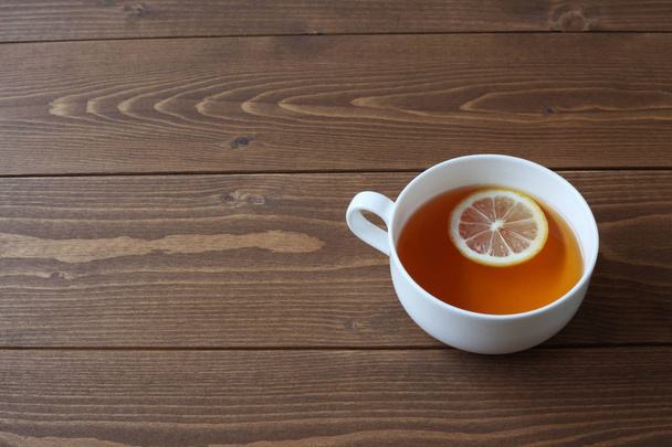 tahta masada izole dilimlenmiş limon ile çay fincan - Fotoğraf, Görsel