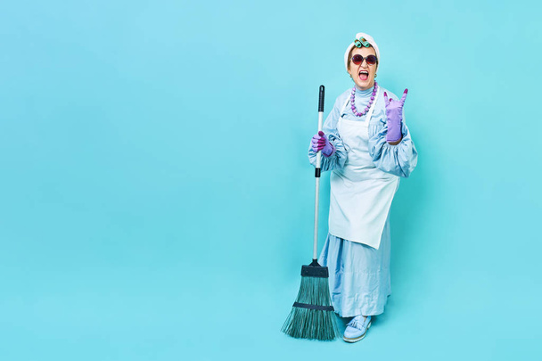 Cleaning Lady Fun. Elderly funky housewife fooling around with a broom. Full body isolated. - Photo, Image