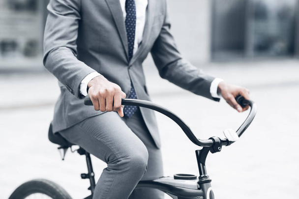 ハンドルバーに手をつないで自転車で仕事に乗るビジネスマン - 写真・画像
