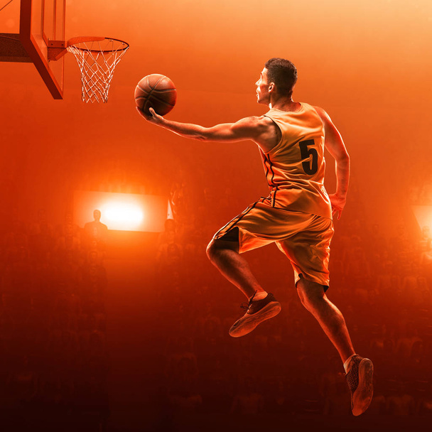 Jogador de basquete em uniforme esportivo em uma arena de basquete profissional em ação com a bola. Bate em cheio. Tiro de salto. Vermelho fundo iluminado
 - Foto, Imagem