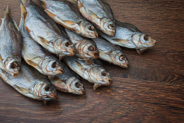 деякі сушені риби на темному дерев'яному фоні
 - Фото, зображення