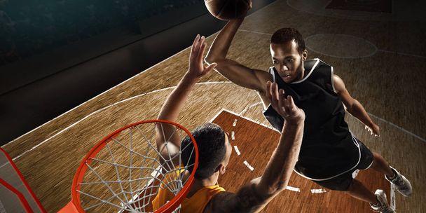 Basketballer kämpfen in der Nähe des Basketballfeldes um den Ball. Blick aus dem Reifen - Foto, Bild