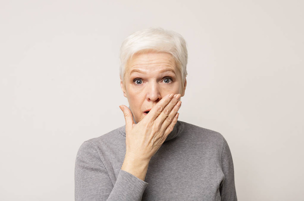Shocked senior lady covering her mouth with hand - Foto, Imagem
