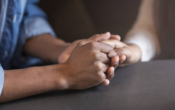 Cropped image of mixed race couple in love holding hands - Photo, Image