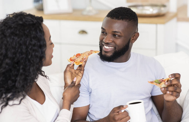 Millennial Couple manger de la pizza et boire du café, se détendre à la maison
 - Photo, image
