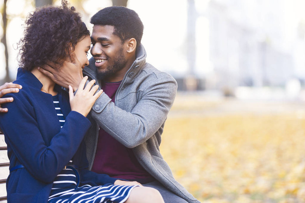 Afrikanischer Mann umarmt seine hübsche Frau und sagt süße Worte - Foto, Bild