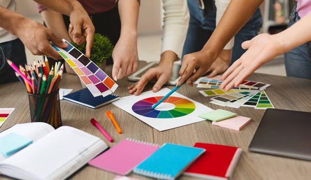 Ryhmä nuoria graafisia suunnittelijoita valitsemalla väripalan näytteitä
 - Valokuva, kuva