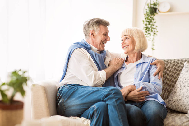 Senior affectionate couple relaxing on sofa at home - Photo, Image