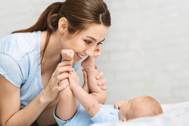 Happy mother playing with her newborn baby at home - Foto, Bild