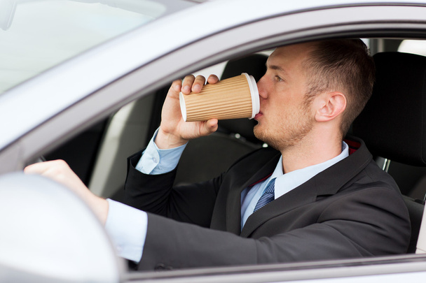 Man drinking coffee while driving the car - Fotoğraf, Görsel