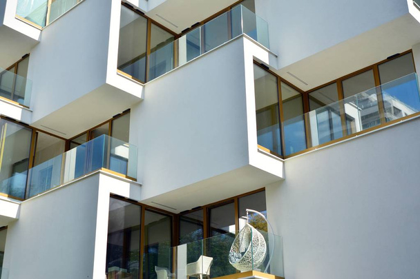 Mavi gökyüzü olan güneşli bir günde modern apartman binaları. Modern bir apartmanın cephesi - Fotoğraf, Görsel