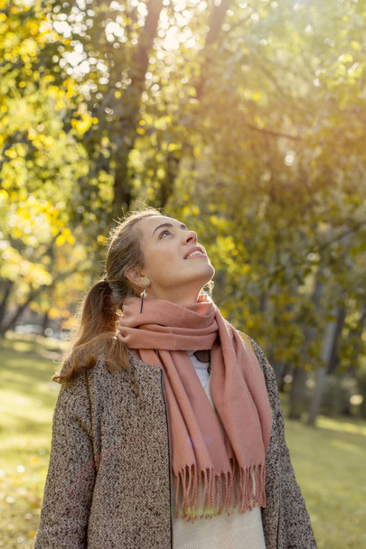 Krásná podzimní žena držící venku žlutý javorový list.  - Fotografie, Obrázek