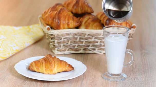 Las mujeres vertían café expreso en una taza de leche para hacer un café con leche al lado de la mantequilla croissant
 - Metraje, vídeo