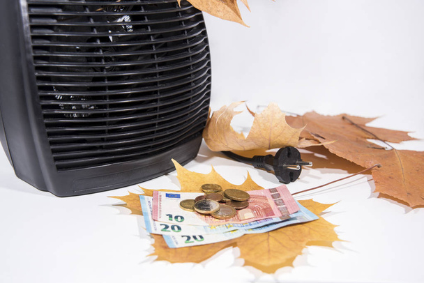 Dinero para facturas de calefacción con calentador negro sobre fondo blanco. Temporada de otoño
. - Foto, imagen