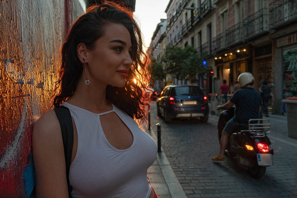 Young beautiful smiling brunette woman at street in European old town. Travel blogger. Freedom and freelancer concept. - Fotó, kép
