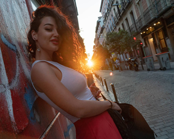 Young beautiful smiling brunette woman at street in European old town. Travel blogger. Freedom and freelancer concept. - 写真・画像