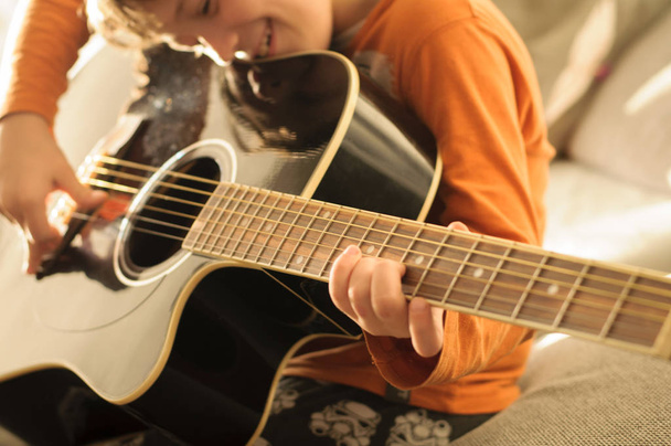 dziecko z czarną gitarą akustyczną - Zdjęcie, obraz