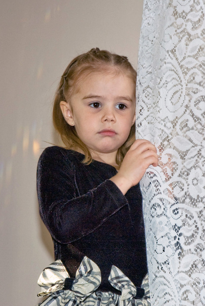θλιβερή μικρό κορίτσι σας αναζητούν έξω από ένα παράθυρο - Φωτογραφία, εικόνα