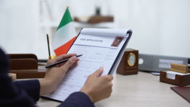 Embassy employee approving visa application, italian flag on table, government - Footage, Video