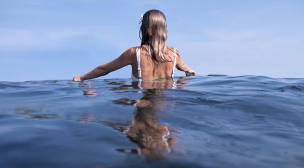 Relaxing on beach resort. Beautiful woman enjoying seascape, standing in the water. - Zdjęcie, obraz