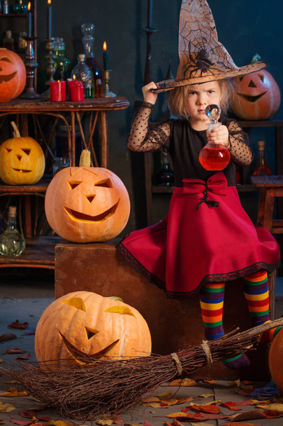 little witch with Halloween pumpkins indoor - Photo, Image