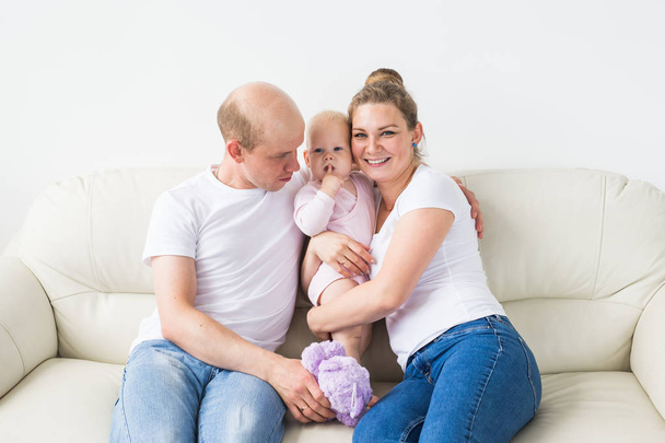 stolze Mutter und Vater lächeln ihre neugeborene Tochter zu Hause an - Foto, Bild