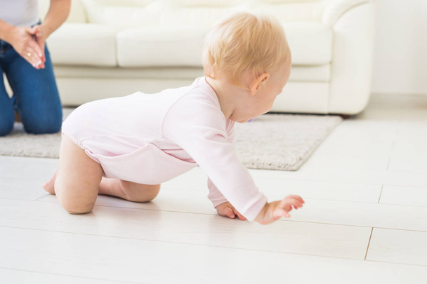 Smiling crawling baby girl at home on floor - Foto, imagen