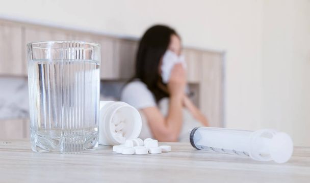 Grypa medycyna kobieta zakażony rezygnować zimno ten lek jest umieszczony od stół i pewien szklanka od woda. - Zdjęcie, obraz