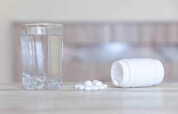Médicament contre la grippe le médicament est placé sur la table et un verre d'eau
. - Photo, image