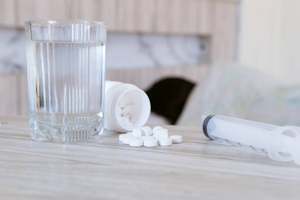 Médicament contre la grippe le médicament est placé sur la table et un verre d'eau
. - Photo, image