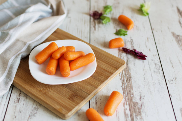 Small baby carrots on cutting board. - Photo, Image